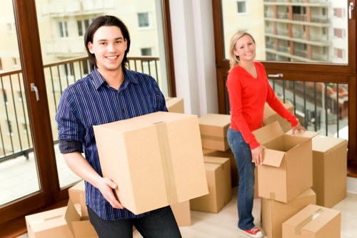 Professional movers handling furniture and IT equipment in a Soho office